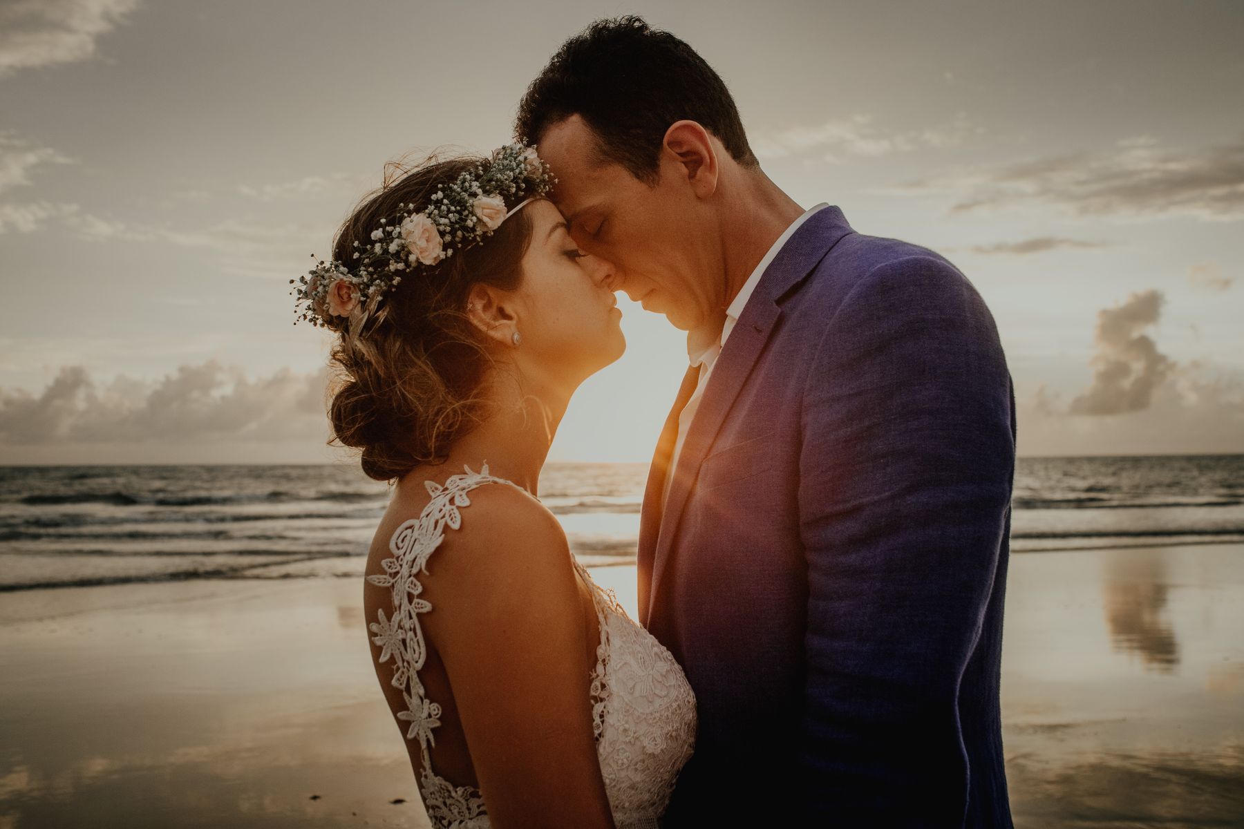 A couple kissing on a beach at sunset