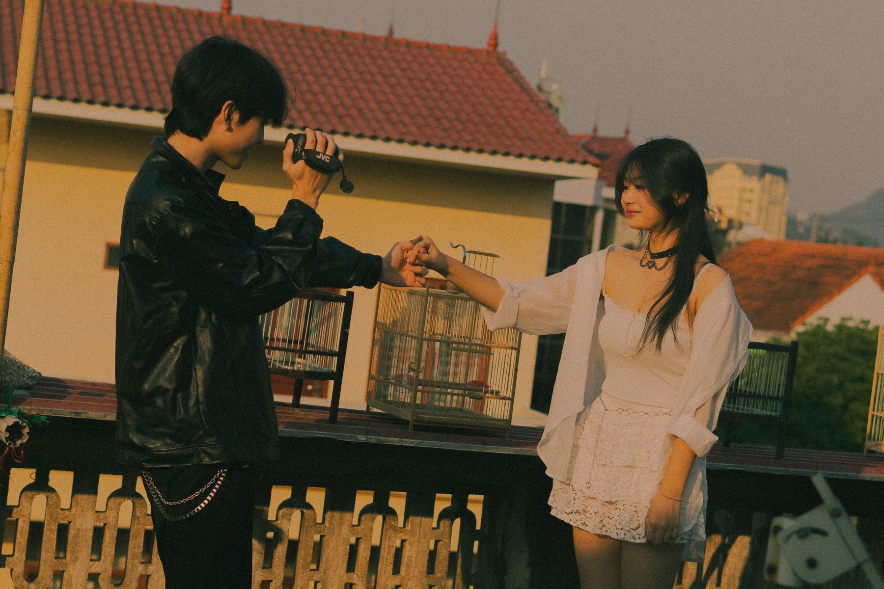 A couple on a rooftop with a camcorder