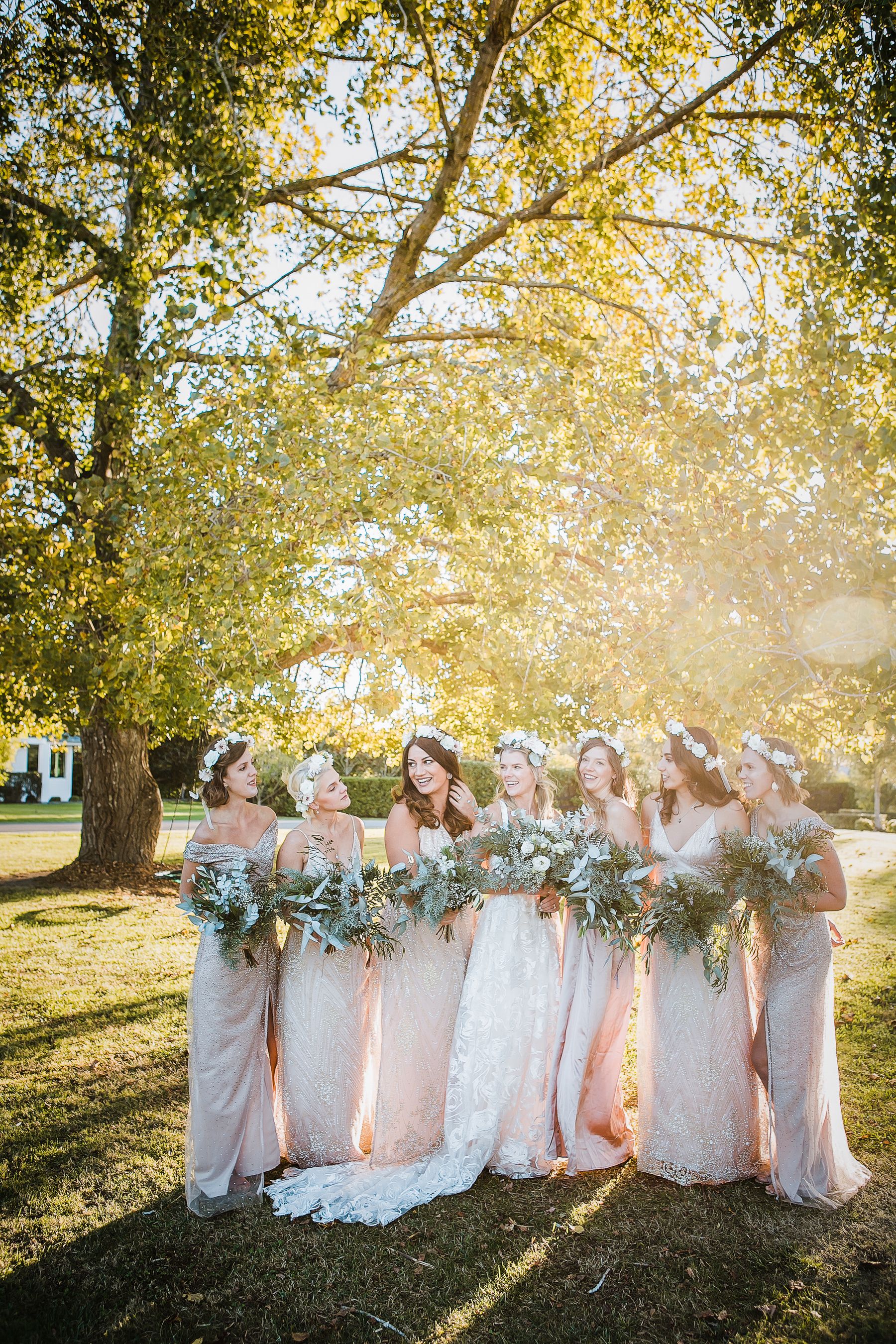 A bride and her bridesmaids under a tree